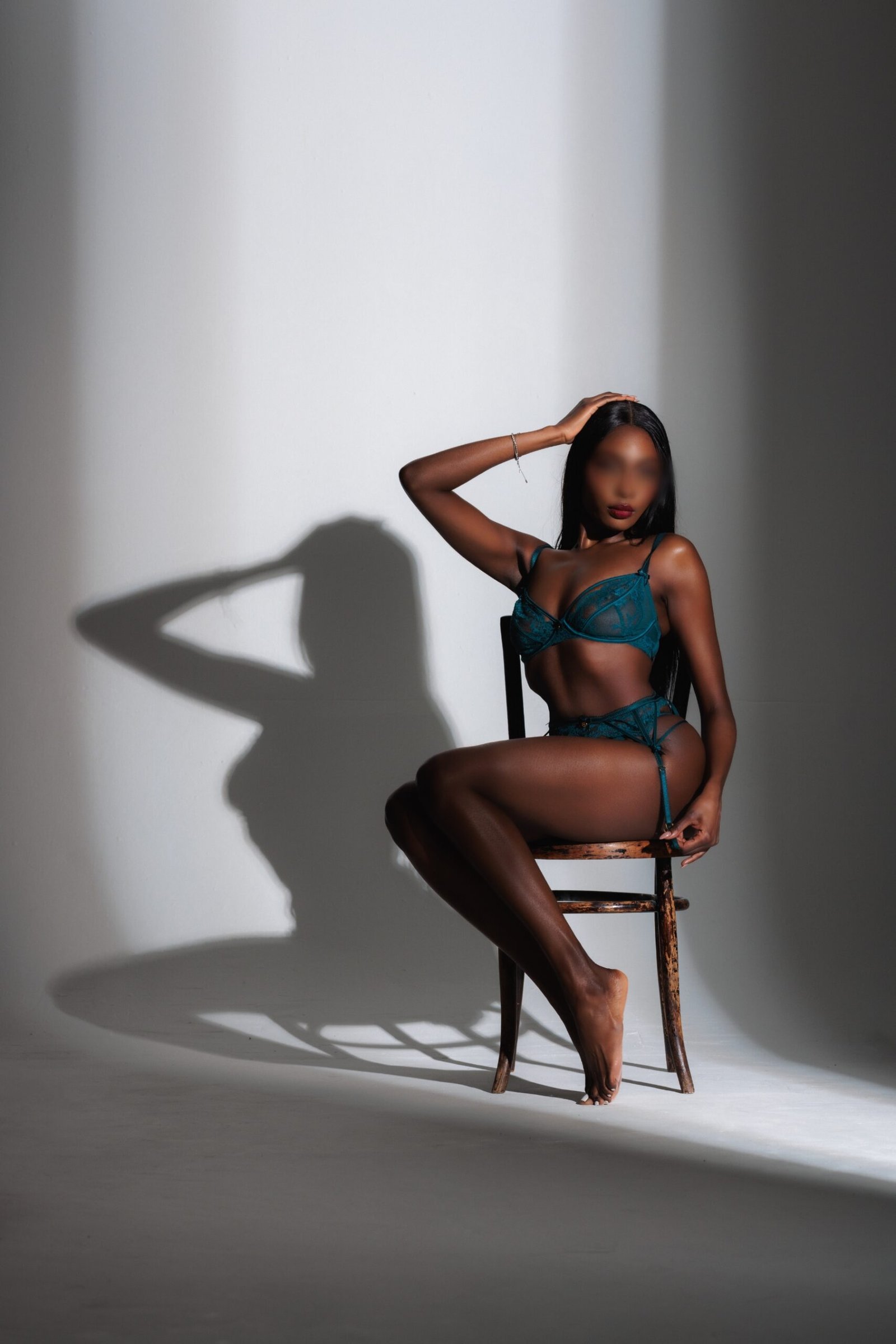 Ada Rose in a seated position in teal lingerie